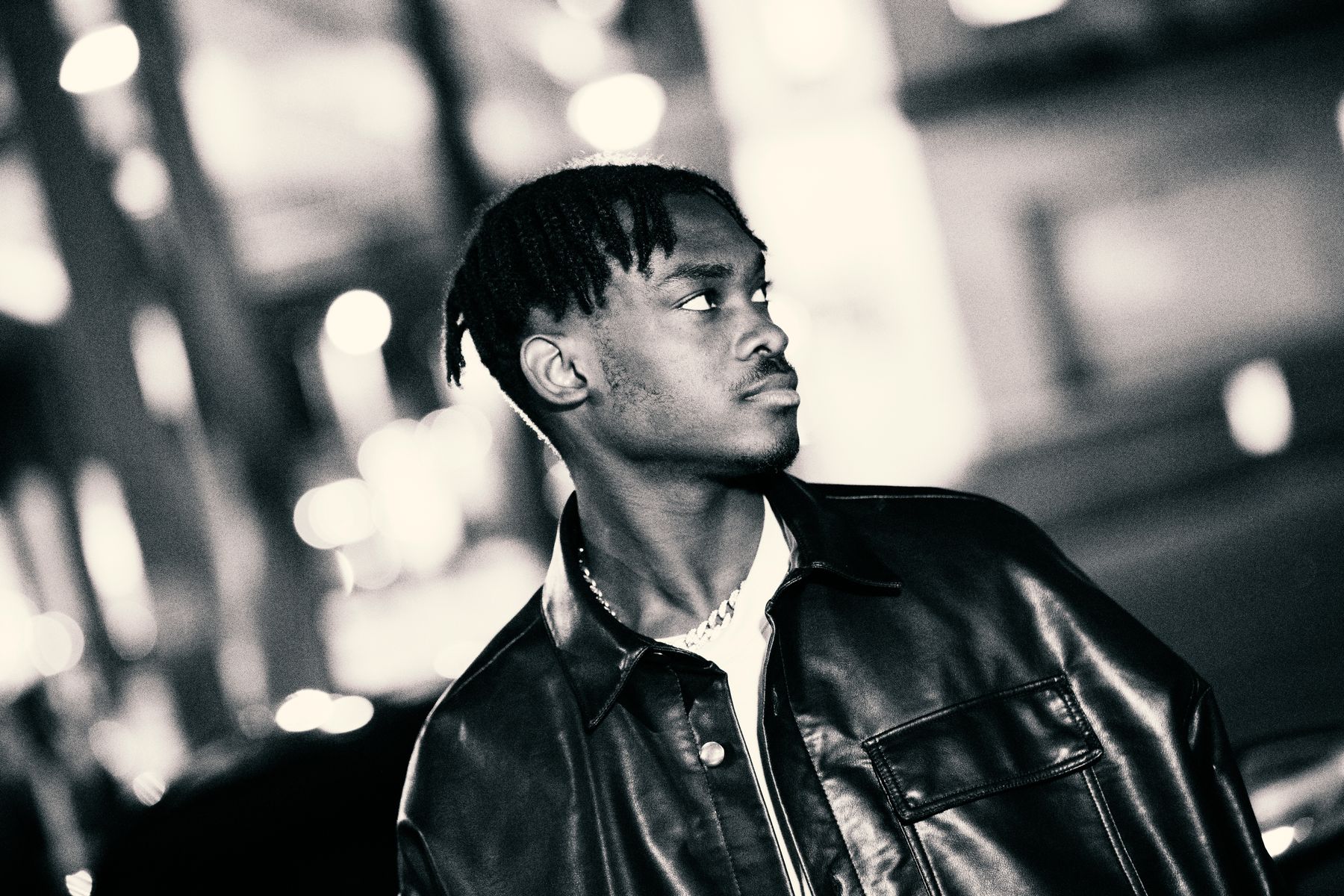 Black-and-white editorial portrait of an artist wearing a leather jacket